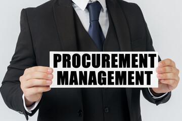 A businessman holds a sign in his hands which says - PROCUREMENT MANAGEMENT