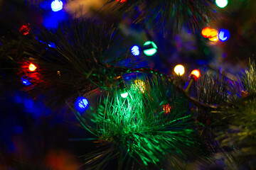 Beautiful Christmas garland glows in the dark on The new year tree. Christmas and new year holidays. Christmas tree decoration.