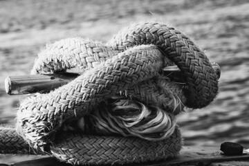 Nautical knot on the dock with water in background - B&W