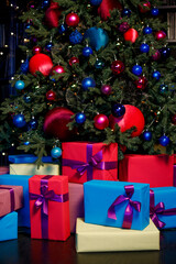 A Christmas tree decorated with balls, and underneath are colorful gifts. 