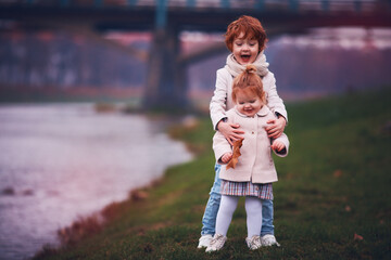 Fototapeta premium cute happy redhead kids, siblings are plaing outdoors. autumn season
