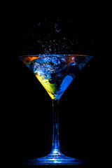 Cocktail multicolor en copa de martini sobre fondo negro