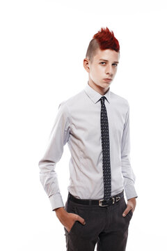 Portrait of serious teen with red mohawk wearing shirt and tie while looking at camera. Isolated