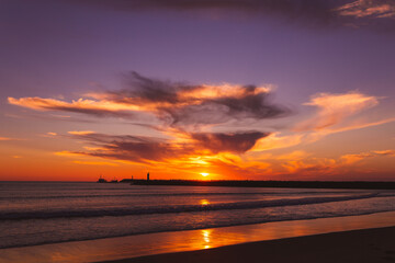Fototapeta na wymiar sunset on the beach in the Atlantic ocean Viana do Castelo Praia do Cabedelo Cabedelo beach colorful clouds with a lighthouse