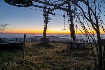 Ein Skilift auf einer Bergwiese im Sonnenuntergang