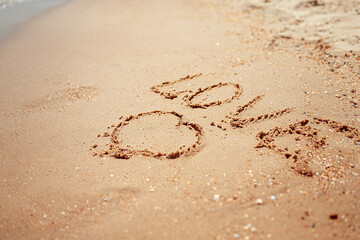 Handwritten Love Word on the Sand Coast. Wonderful words on beach sand. Love idea concept.