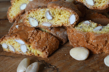 Close-up on cantucci or cantuccini on wooden background with shelled almonds. Cantuccini are typical Tuscan dry biscuits, made with flour, eggs, yeast and almonds. Italy.