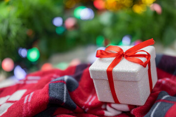 surprise gift with a red bow on a cozy plaid