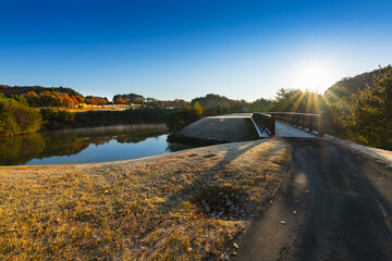 日本　早朝で朝霜の紅葉のゴルフ場池と橋