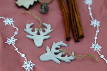 Various Christmas decorations and cinnamon sticks on pink background. Selective focus.