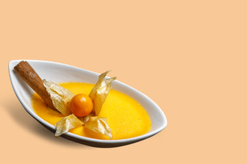 Cream pudding in a plate decorated with physalis. Copy space