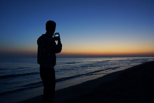 Shot of a man taking a photo of sunset over the Lake Sevan