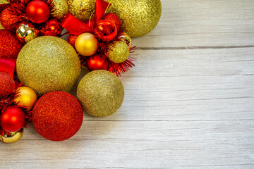 Christmas border of gold and red balls on a white wooden background. New year greeting card Copy space.