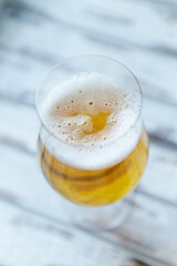Glass of beer on bright wooden background. Close up.	