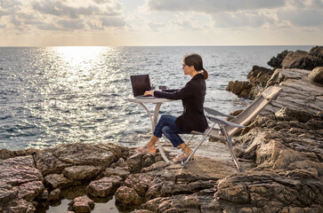Business woman working from the beach. Working from distance concept. Freelancer travel and work...