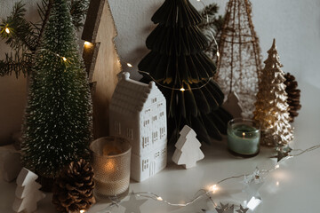 Merry Christmas. Christmas little ceramic house, wooden fir trees. 