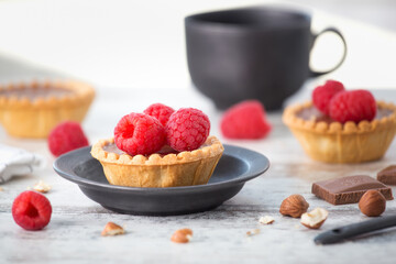 Cake with fresh raspberries and chocolate on the table.