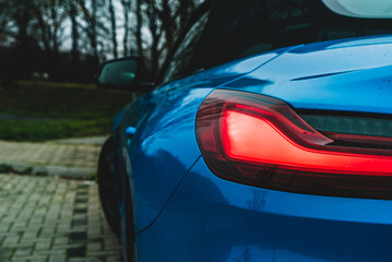 Red shining taillight on blue sports car
