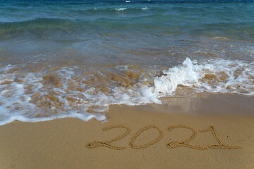 Happy new year 2021 written in the sand.Happy new year 2021 written in the sand by the sea.