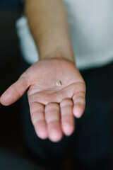 View of a child's hand holding the their lost tooth