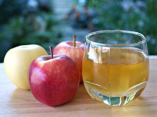 Apple juice and yellow red apple fruit on wooden background