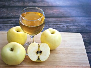 Apple juice and yellow apples fruit on wooden background	