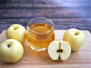 Apple juice and yellow apples fruit on wooden background	