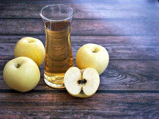 Apple juice and yellow apples fruit on wooden background	