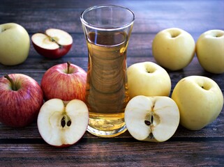 Apple juice and yellow apples fruit on wooden background	