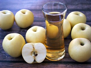 Apple juice and yellow apples fruit on wooden background	