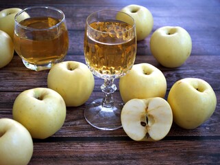 Apple juice and yellow apples fruit on wooden background	