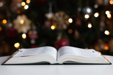Bible open in front of Christmas tree