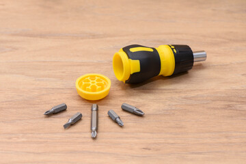 Yellow-black handle screwdriver still life. Detailed macro photography of the compact multi tool...