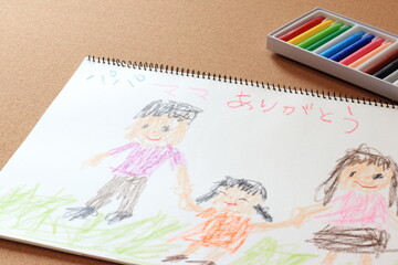 Fototapeta na wymiar クレヨンでスケッチブックに描かれた家族の絵