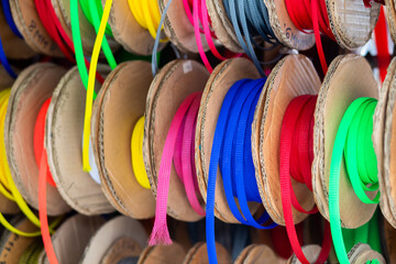 There are many different multi-colored skeins of ribbons in the store, close up