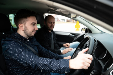 Young Man Having Driving Lesson With Male Instructor