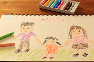 クレヨンでスケッチブックに描かれた家族の絵