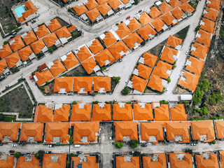 Top view of old european city with orange roofs. Lined up residential buildings with red tiled roofs