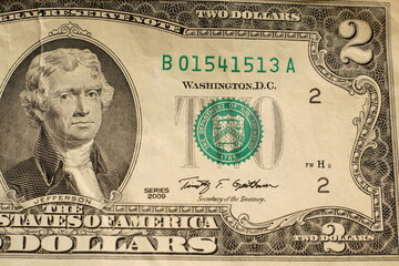 A two-dollar bill. Closeup. With drawings on the banknote itself.