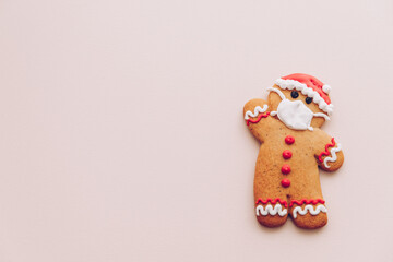 Fototapeta na wymiar Minimalist Christmas background with gingerbread cookies with the image of a protective medical mask on the face. The concept of celebrating the New Year 2021 in quarantine during a lockdown.