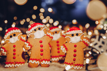 Happy New Year's set of gingerbread man in face mask from ginger biscuits glazed sugar icing decoration on xmas background, colorful seasonal pandemic winter holiday banner