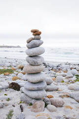 Object of the stones on the beach at sunset.Pyramid of stones against the sunset cloudy sky.