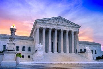 View of marble columns and greek classical architecture of the United States Supreme Court building with sunrise in background