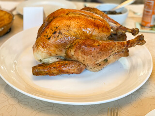 Above closeup photo of a roasted turkey on a white platter.