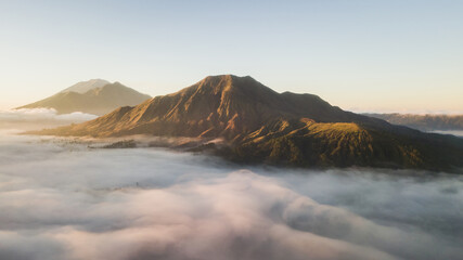 Aerial view of mount Batur volcano in Bali. Beautiful sunrise and low clouds. Panoramic view.