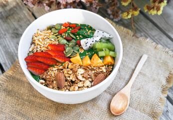 Breakfast Detox Green Smoothie bowls  from Green tea and Spinach with fruits, nuts, seeds and homemade granola and strawberry for healthy vegan vegetarian.