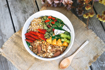 Top view for Green Smoothie bowls  from Green tea and Spinach with fruits, nuts, seeds and homemade granola and strawberry for healthy vegan vegetarian.
