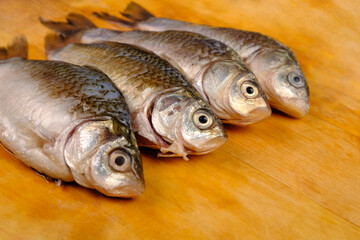 crucian carp on a wooden surface, fresh peeled fish close-up