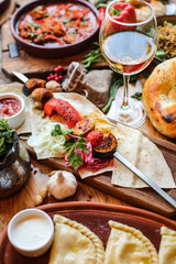 Muslim Ramadan iftar family dinner. Flat-lay of people feasting over table with Middle East food. Dates, dolma, kebab, flatbread, pide, borek, sweet, salad, top view. Ramazan fasting Turkish cuisine.
