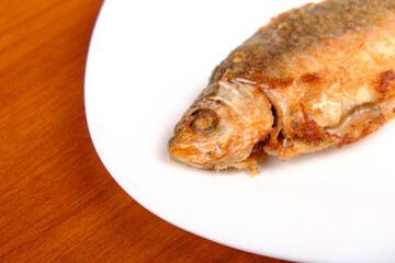 fried crucian carp on a plate, cooked fish